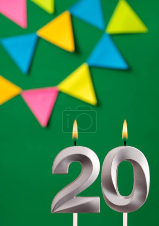 Foto de Tarjeta de cumpleaños vertical con número 20 vela Fondo verde con banderines - Imagen libre de derechos