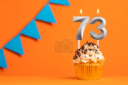 Foto de Vela número 73 - Cumpleaños de pastel en fondo naranja - Imagen libre de derechos