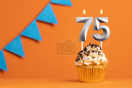 Foto de Vela número 75 - Cumpleaños de pastel en fondo naranja - Imagen libre de derechos