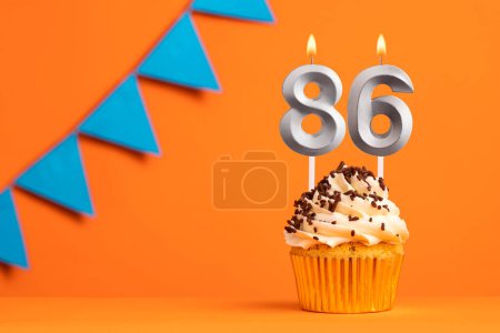 Foto de Tarta de cumpleaños con número de vela 86 - Fondo naranja - Imagen libre de derechos