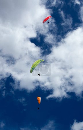 Photo for Three paragliders flying in the blue sky against the background of clouds. Paragliding in Cocorna, a municipality in Colombia - Royalty Free Image