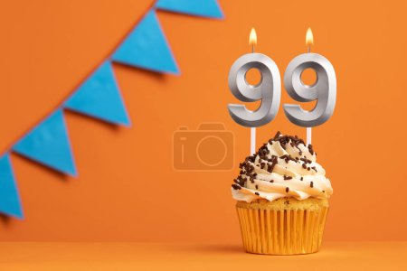 Foto de Vela número 99 - Cumpleaños de pastel en fondo naranja - Imagen libre de derechos