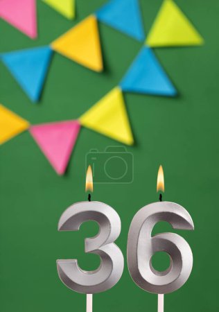 Foto de Tarjeta de cumpleaños vertical con número 36 vela Fondo verde con banderines - Imagen libre de derechos
