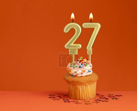 Foto de Número 27 vela - Diseño de la tarjeta de cumpleaños en fondo naranja - Imagen libre de derechos