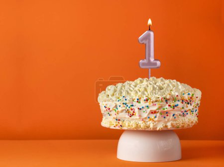 Téléchargez les photos : Carte d'anniversaire avec bougie numéro 1 - Gâteau à la vanille en fond orange - en image libre de droit