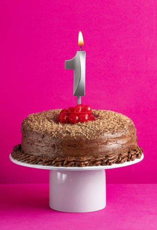 Téléchargez les photos : Bougie numéro 1 gâteau au chocolat sur fond rose - en image libre de droit
