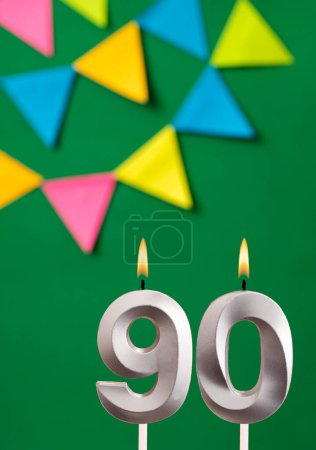 Foto de Tarjeta de cumpleaños vertical con número 90 vela Fondo verde con banderines - Imagen libre de derechos