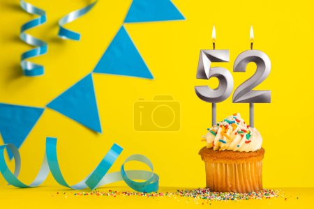 Foto de Vela de cumpleaños número 52 - Fondo amarillo con banderines azules - Imagen libre de derechos