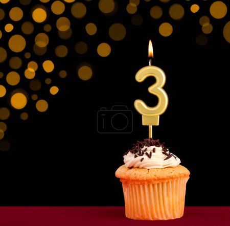 Photo for Number 3 birthday candle - Cupcake on black background with out of focus lights - Royalty Free Image