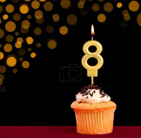 Photo for Birthday candle with cupcake - Number 8 on black background with out of focus lights - Royalty Free Image