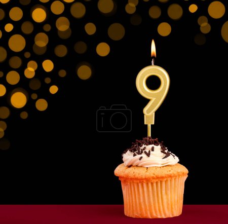 Photo for Number 9 birthday candle - Cupcake on black background with out of focus lights - Royalty Free Image