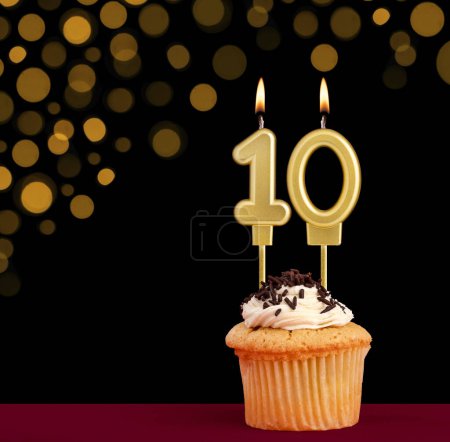 Photo for Birthday candle with cupcake - Number 10 on black background with out of focus lights - Royalty Free Image