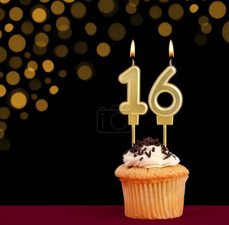 Photo for Birthday candle with cupcake - Number 16 on black background with out of focus lights - Royalty Free Image