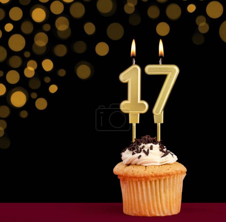 Photo for Number 17 birthday candle - Cupcake on black background with out of focus lights - Royalty Free Image