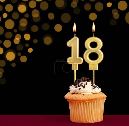 Photo for Birthday candle with cupcake - Number 18 on black background with out of focus lights - Royalty Free Image