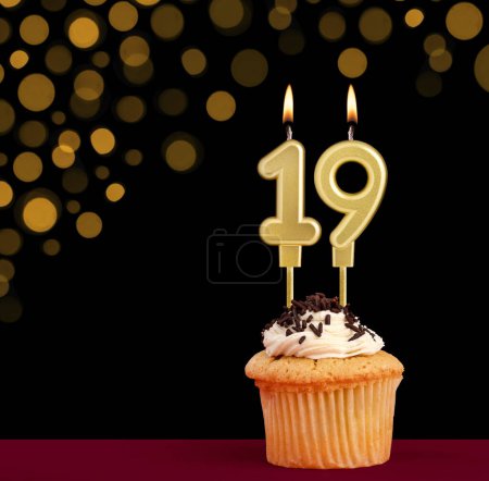 Photo for Number 19 birthday candle - Cupcake on black background with out of focus lights - Royalty Free Image