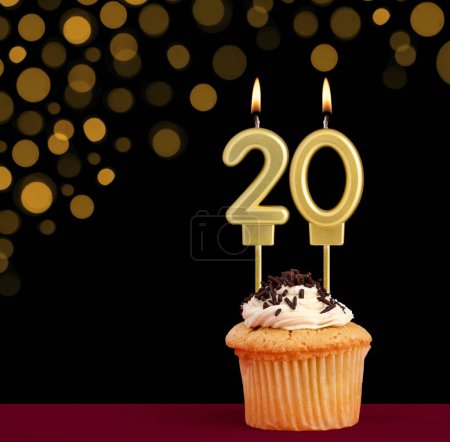 Photo for Birthday candle with cupcake - Number 20 on black background with out of focus lights - Royalty Free Image