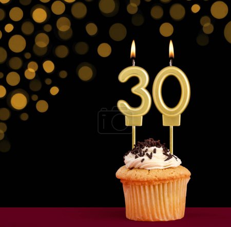 Photo for Birthday candle with cupcake - Number 30 on black background with out of focus lights - Royalty Free Image