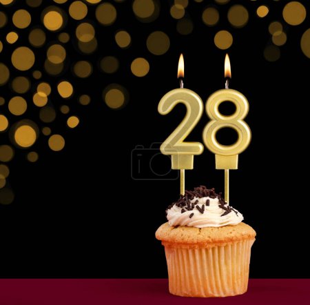 Photo for Birthday candle with cupcake - Number 28 on black background with out of focus lights - Royalty Free Image