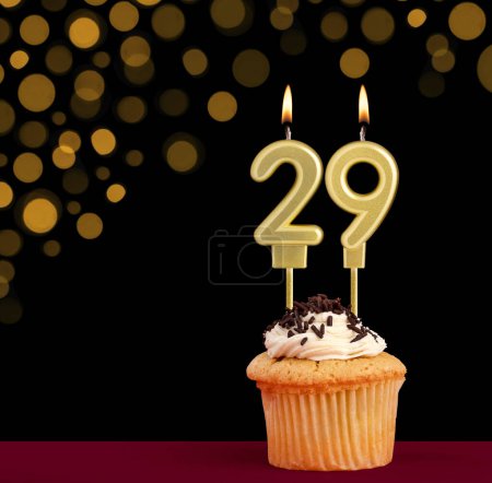 Photo for Number 29 birthday candle - Cupcake on black background with out of focus lights - Royalty Free Image