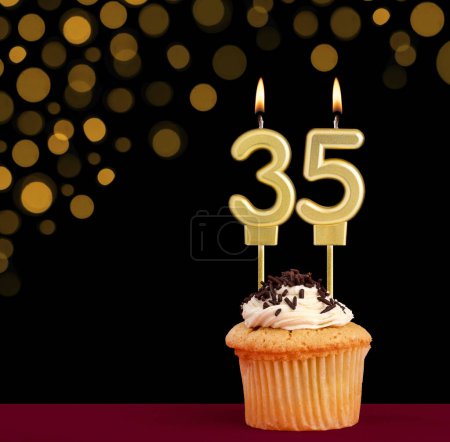 Photo for Number 35 birthday candle - Cupcake on black background with out of focus lights - Royalty Free Image