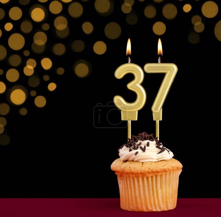 Photo for Number 37 birthday candle - Cupcake on black background with out of focus lights - Royalty Free Image