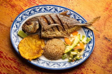 Photo for Fried horse mackerel served with patacon, coconut rice and vegetable salad - Food from the South Pacific - Royalty Free Image