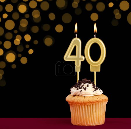 Photo for Birthday candle with cupcake - Number 40 on black background with out of focus lights - Royalty Free Image