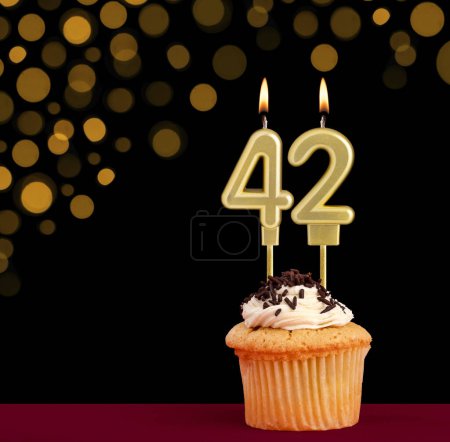 Photo for Birthday candle with cupcake - Number 42 on black background with out of focus lights - Royalty Free Image