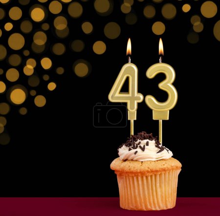 Photo for Number 43 birthday candle - Cupcake on black background with out of focus lights - Royalty Free Image