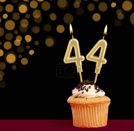 Photo for Birthday candle with cupcake - Number 44 on black background with out of focus lights - Royalty Free Image