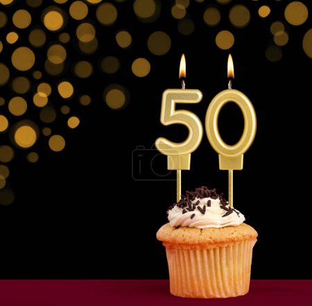 Photo for Birthday candle with cupcake - Number 50 on black background with out of focus lights - Royalty Free Image