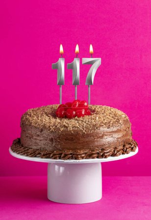 Photo for Number 117 candle - Chocolate cake on pink background - Royalty Free Image