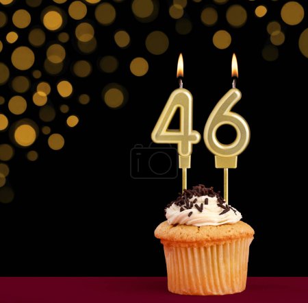 Photo for Birthday candle with cupcake - Number 46 on black background with out of focus lights - Royalty Free Image