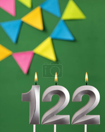 Foto de Número de vela 122 cumpleaños - Tarjeta de aniversario verde con banderines - Imagen libre de derechos