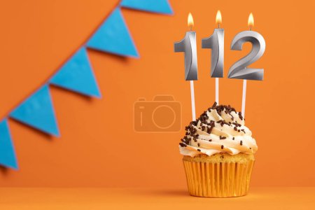 Foto de Tarta de cumpleaños con número de vela 112 - Fondo naranja - Imagen libre de derechos