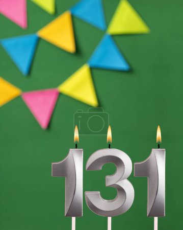 Téléchargez les photos : Carte d'anniversaire verticale avec numéro 131 bougie - fond vert avec des fanions - en image libre de droit