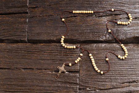 Photo for Holy catholic rosary and a cross - wooden background - Royalty Free Image