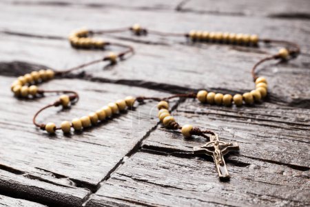 Photo for Catholic rosary, necklace made of wood - Wooden background - Royalty Free Image