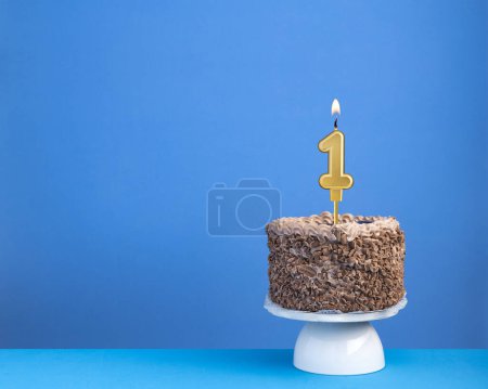 Téléchargez les photos : Célébration d'anniversaire avec bougie 1 gâteau au chocolat sur fond bleu - en image libre de droit