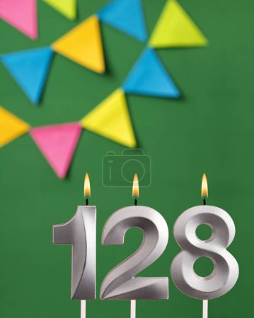 Téléchargez les photos : Bougie numéro 128 anniversaire - Carte d'anniversaire verte avec des fanions - en image libre de droit