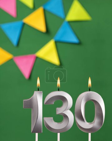 Foto de Número de vela 130 cumpleaños - Tarjeta de aniversario verde con banderines - Imagen libre de derechos