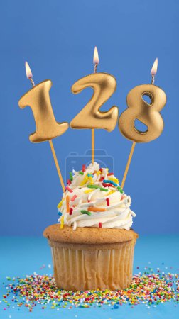 Téléchargez les photos : Cupcake d'anniversaire avec bougie numéro 128 - fond bleu - en image libre de droit