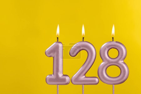 Téléchargez les photos : Bougie 128 avec flamme - Carte d'anniversaire sur fond jaune luxe - en image libre de droit