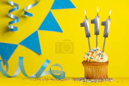 Foto de Vela de cumpleaños número 111 - Fondo amarillo con banderines azules - Imagen libre de derechos
