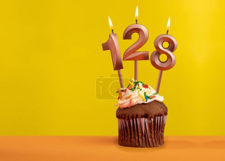 Téléchargez les photos : Bougie d'anniversaire numéro 128 - Célébration sur fond jaune - en image libre de droit