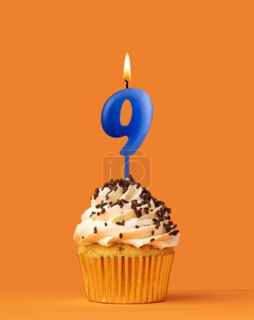 Foto de Vela azul número 9 - Pastel de cumpleaños sobre fondo naranja - Imagen libre de derechos