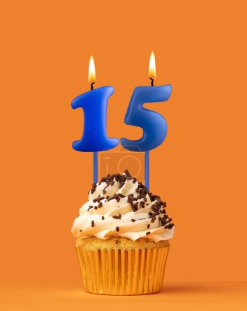 Foto de Vela azul número 15 - Pastel de cumpleaños sobre fondo naranja - Imagen libre de derechos