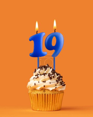 Foto de Vela azul número 19 - Cumpleaños magdalena sobre fondo naranja - Imagen libre de derechos