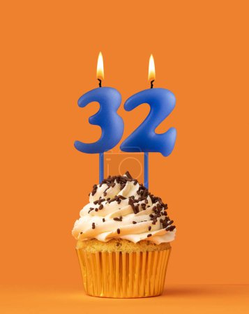 Foto de Vela de cumpleaños azul y magdalena - Número 32 - Imagen libre de derechos